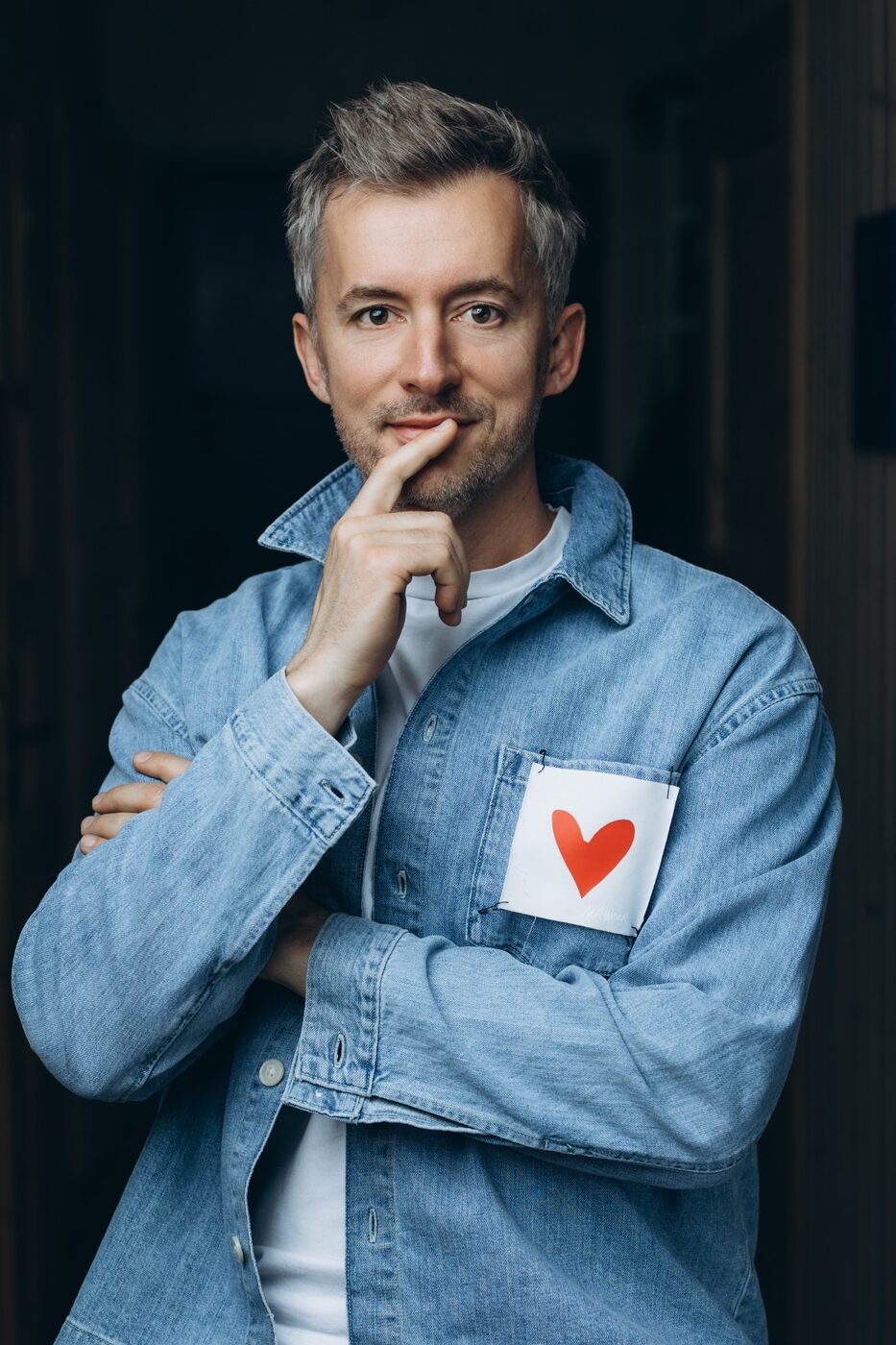 Portrait in a denim jacket with a small red heart on the pocket
